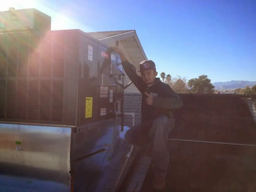 HVAC technician performing Air Duct Repair on a rooftop unit in Lynwood